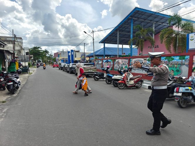 
					Humanis, Satlantas Polres Kotim bantu masyarakat  Menyebrang Jalan Saat Gatur Pagi.