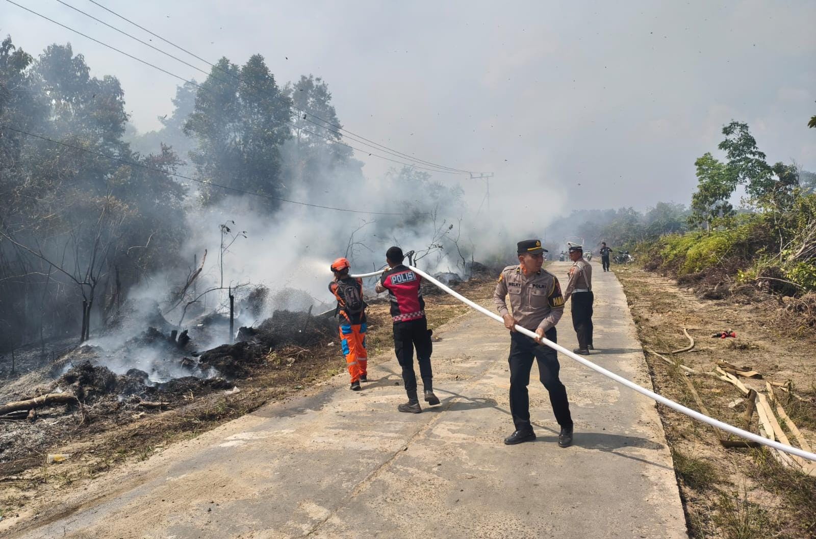 Polres Murung Raya Bersama Tim Satgas Karhutla Terus Berupaya Padamkan Karhutla di Jalan Desa Juking Pajang